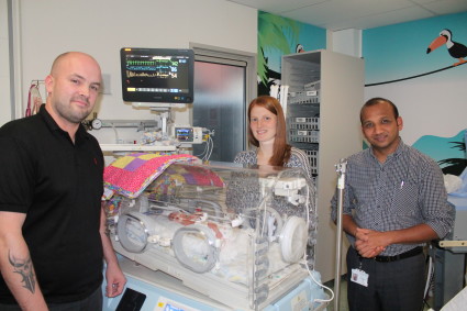 Victoria and Mark Carter by an incubator on the neonatal unit.