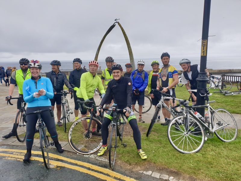 A group of intrepid fundraising cyclists at the whale bones in Whitby.