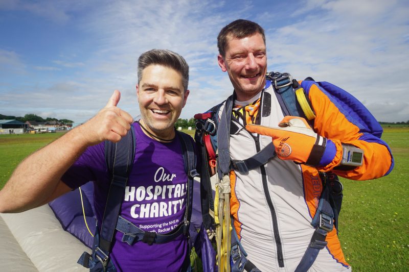 Head of charity Ben Murphy celebrating with a thumbs up after his tandem skydive for Our Hospitals Charity.