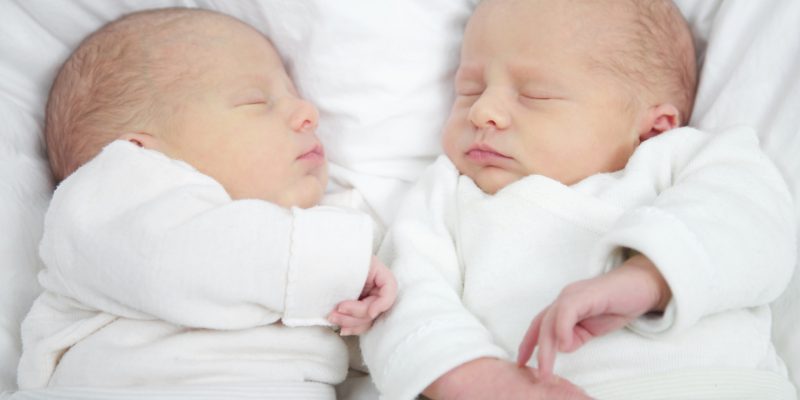 close up of twins fast asleep facing each other