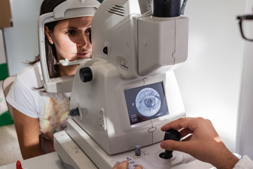 A ophthalmologist using a non-mydriatic retinal camera on a young girl