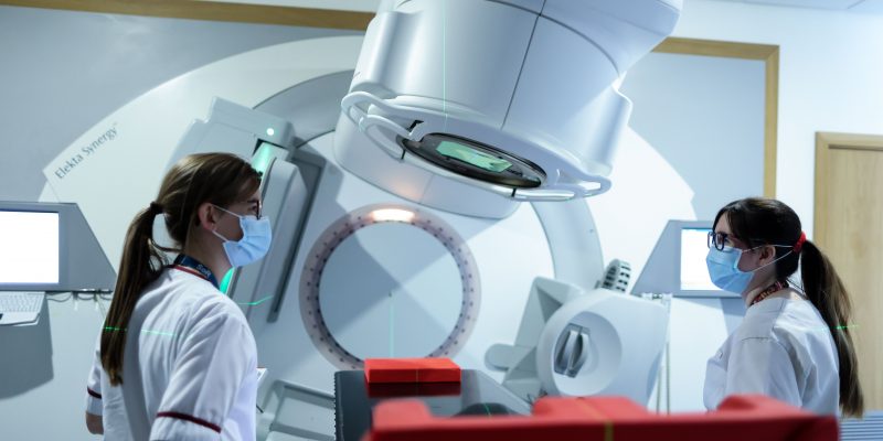 Radiotherapy machine and two staff