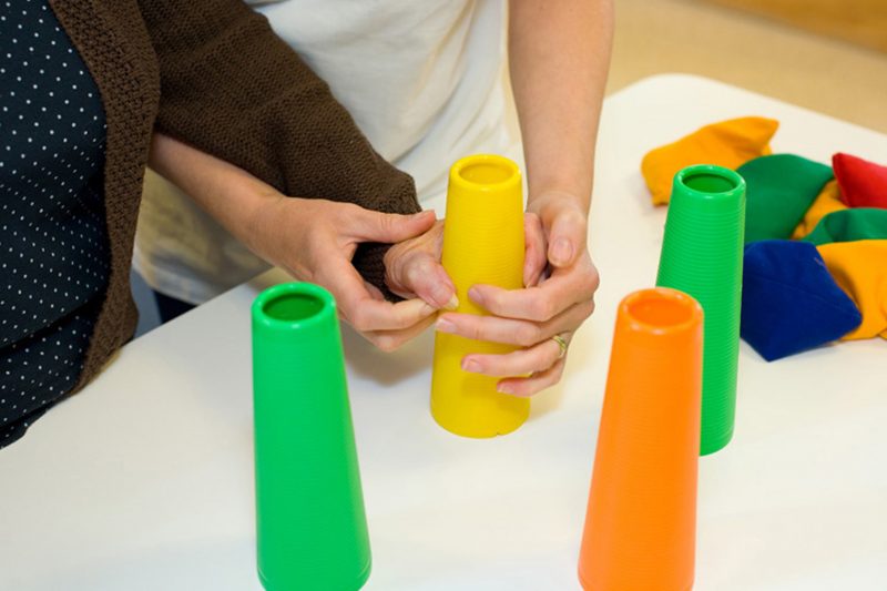 Rehabilitation exercise gripping coloured cones on a table