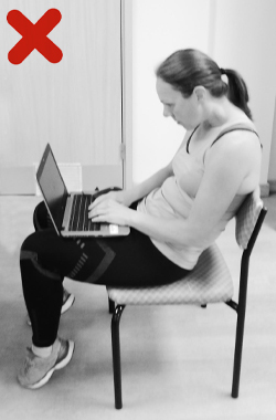 Sitting slouched with laptop on knees