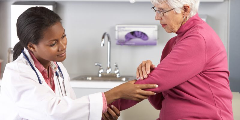 A doctor examining a patients elbow.