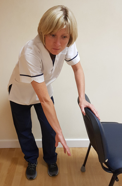 Holding chair for support, affected arm with the palm inwards