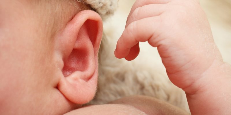 Photograph of a newborn baby focusing in on the ear area 