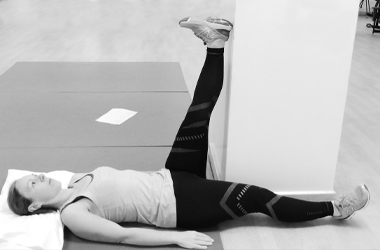 Hamstring exercise with one leg stretching up the wall