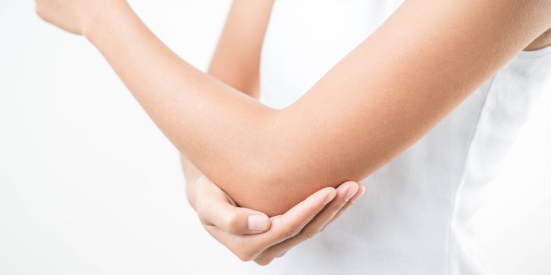 Image showing a person supporting their elbow as if in some pain or discomfort.