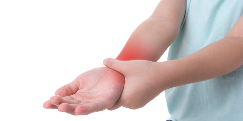 Photograph showing a child holding their wrist in pain