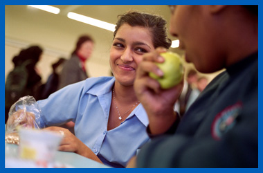 Young person eating lunch with friends in an educational setting