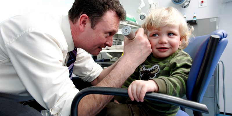 Consultant examining a childs ear