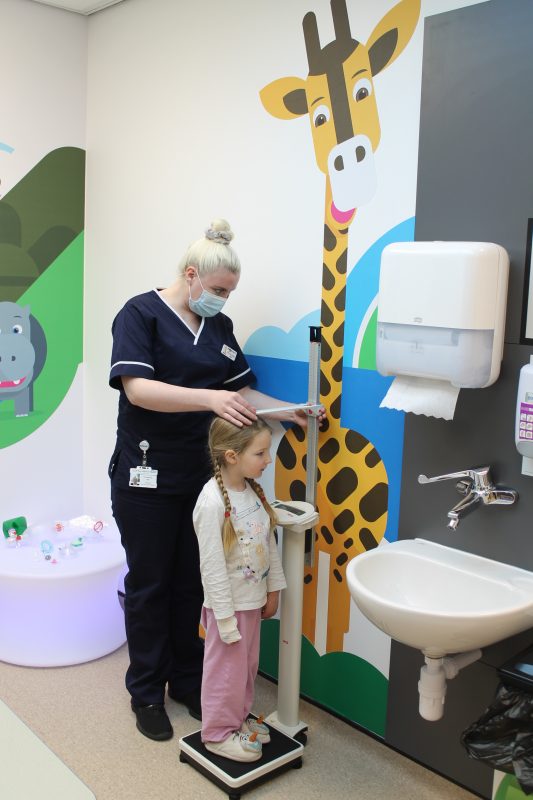 Young girl having height measured by nurse