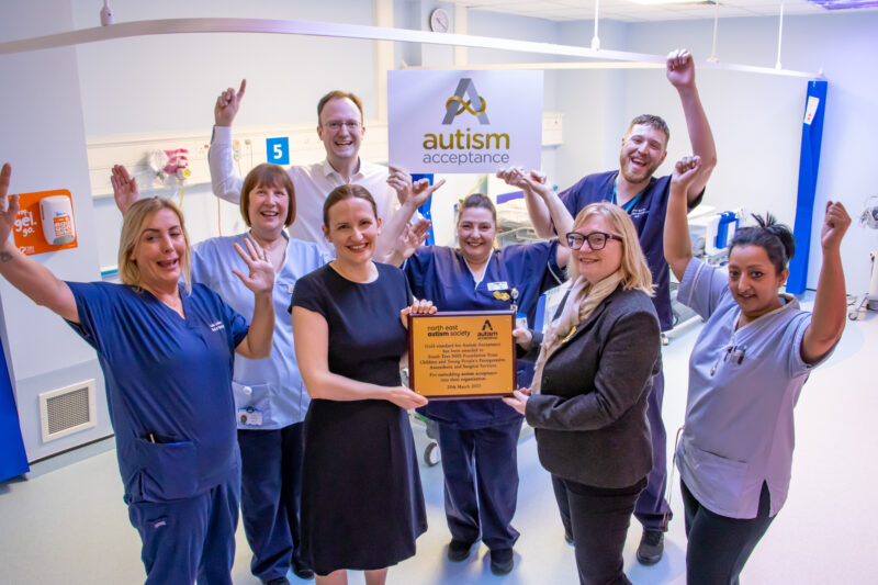 Staff celebrate with gold award plaque