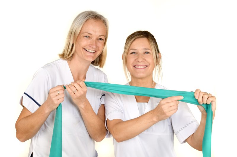 Two physiotherapists holding an exercise band 