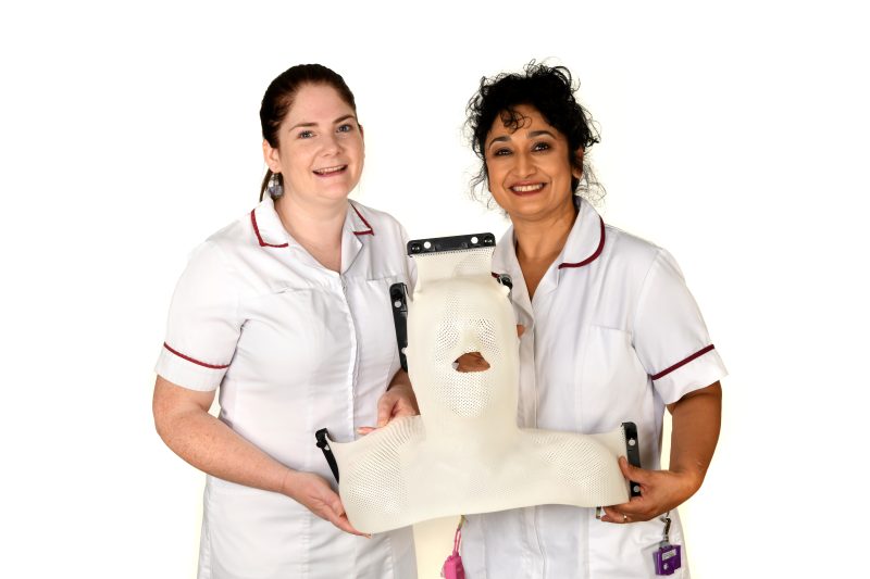 Two therapeutic radiographers holding a cast