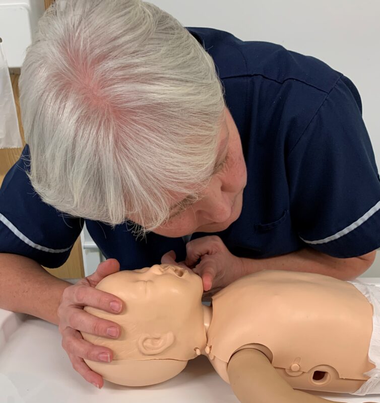 Demonstrating life support skills on baby mannequin - checking airway