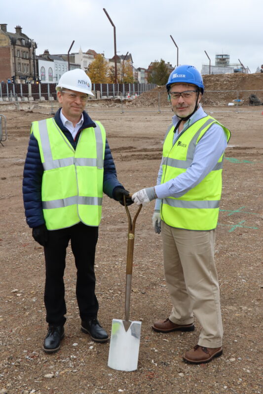 Two radiologists with a spade on the building site of the new clinical diagnostic centre