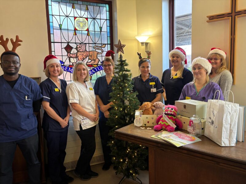 A group pf people stood in front of a Christmas tree