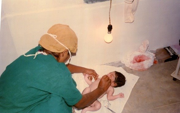 A newborn baby with a medical staff member at Tribal Health Initiative
