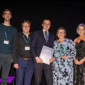 Alistair Levett-Renton, Andrew Simpson, Dave Ferguson, Sharon Brown with presenter Marie Roche, chief operating officer AHSN stood on the stage recieving the award