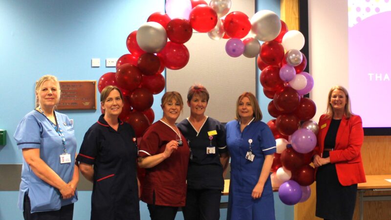 A group of people stood in front of a balloon arch