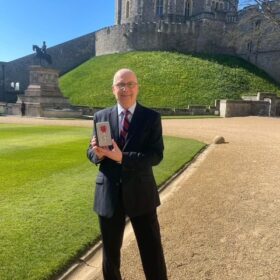 Professor Nick Linker with his MBE outside Windsor Castle