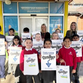 Ellie Young with school children and headteacher Grace Mitchell and Amy Black, from the smokefree team