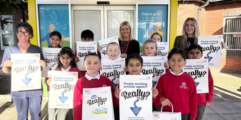 Ellie Young with school children and headteacher Grace Mitchell and Amy Black, from the smokefree team