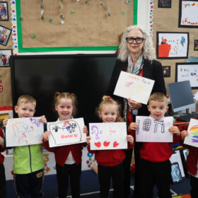 School children holding their artwork
