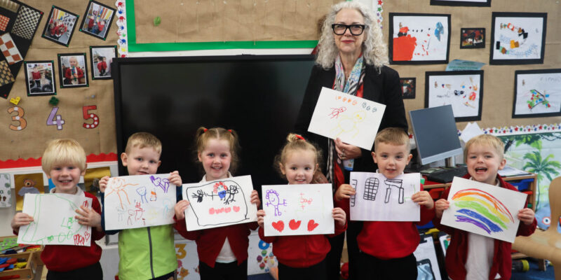 School children holding their artwork