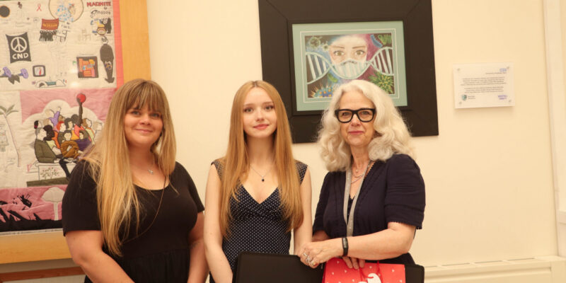 Lainey Garbutt (centre) receives her first place prize in front of her winning artwork.