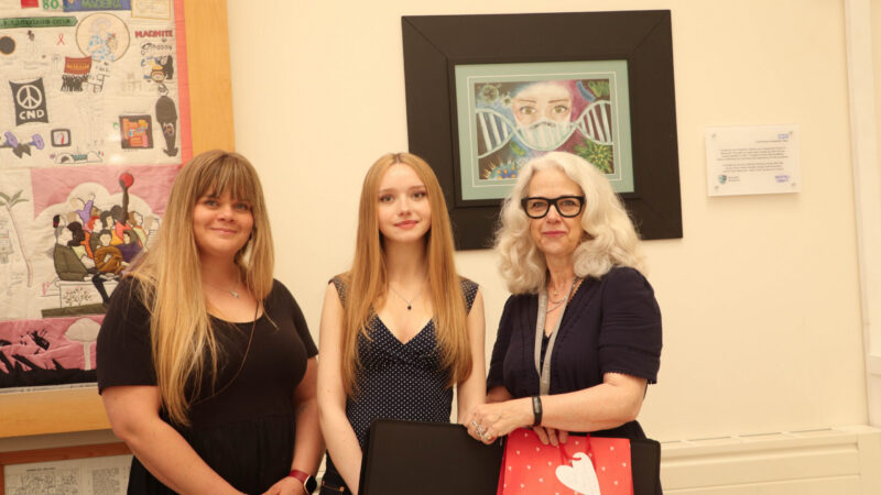 Lainey Garbutt (centre) receives her first place prize in front of her winning artwork.