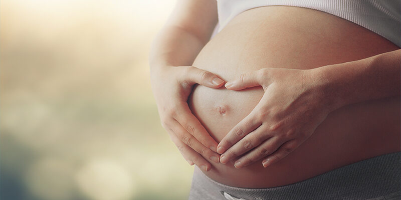 Mother holding her pregnant belly