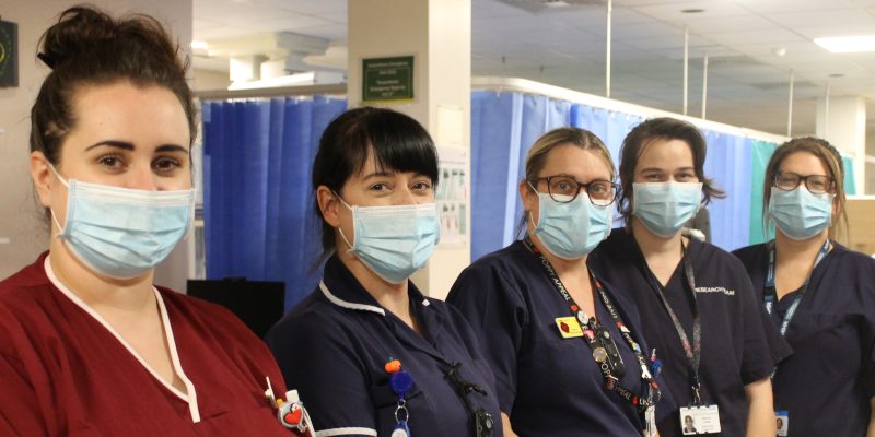The critical care research team stood in a line wearing masks